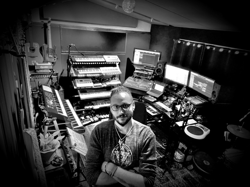 Toby Karlin in his studio surrounded by keyboards, monitors, and instruments