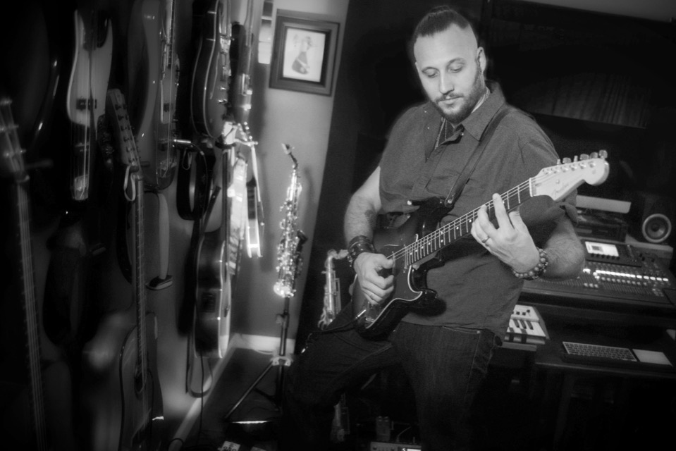 Toby playing electric guitar in the studio