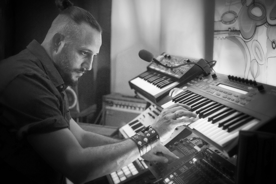 Toby playing saxophone with guitars on the wall